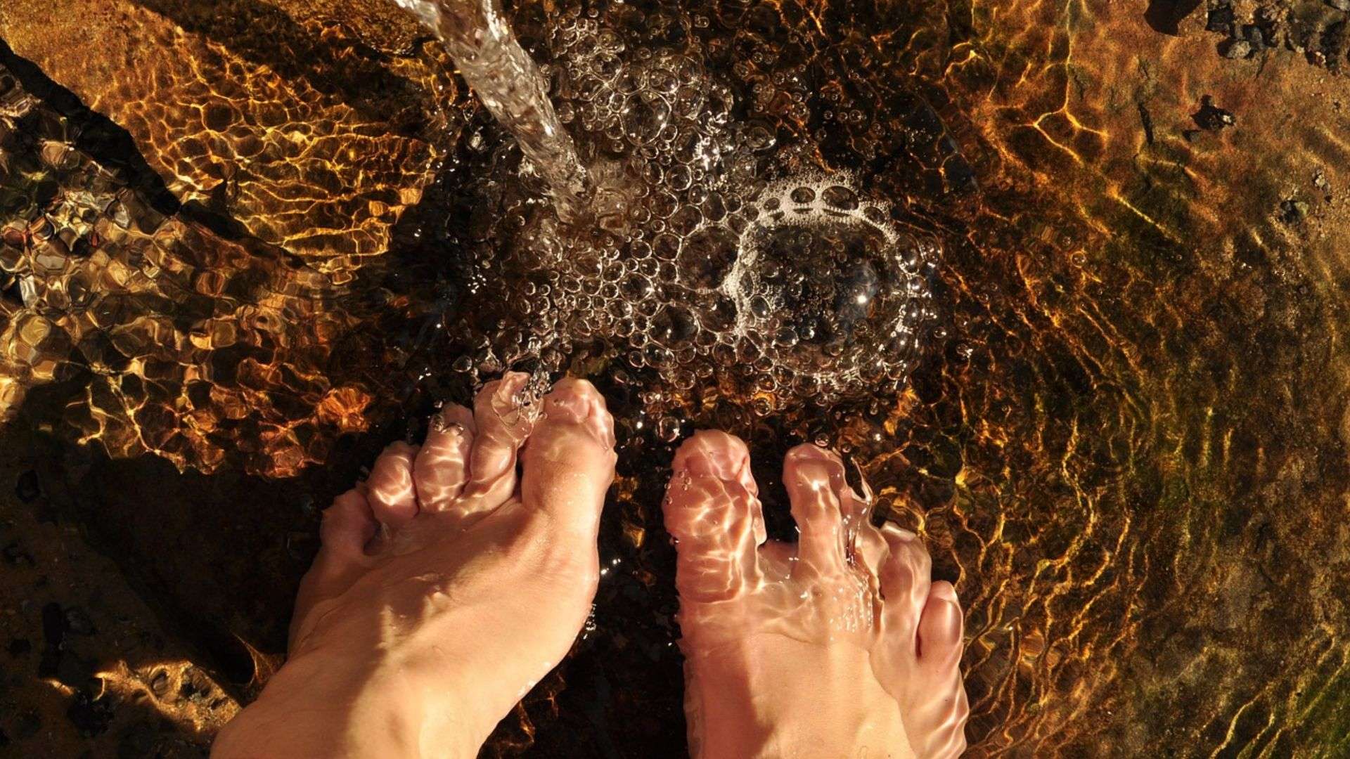 Pies mojándose en el agua del río en una escapada a la sierra de Madrid